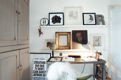 Photo of a small eclectic home office in London with white walls and a freestanding desk.