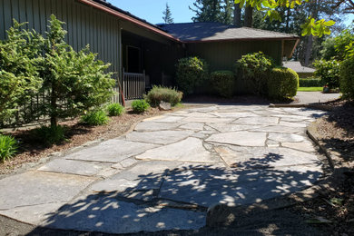 Inspiration for a large rustic front yard stone patio remodel in Portland