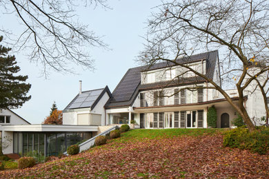 Modelo de fachada de casa blanca y negra clásica grande con revestimiento de estuco y tejado de teja de barro