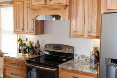 Inspiration for a mid-sized rustic u-shaped medium tone wood floor eat-in kitchen remodel in Other with an undermount sink, shaker cabinets, light wood cabinets, granite countertops, stainless steel appliances and a peninsula