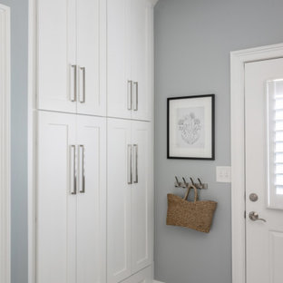 Cette image montre une petit buanderie parallèle traditionnelle dédiée avec un placard à porte shaker, des portes de placard blanches, un plan de travail en quartz modifié, une crédence blanche, une crédence en marbre, un mur bleu, un sol en carrelage de porcelaine, des machines côte à côte, un sol bleu et un plan de travail blanc.