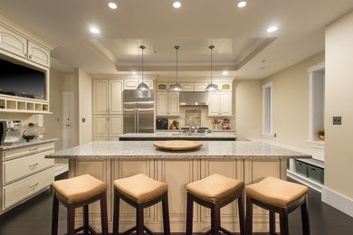 Open concept kitchen - huge transitional dark wood floor open concept kitchen idea in Boston with an undermount sink, raised-panel cabinets, white cabinets, granite countertops, white backsplash, ceramic backsplash, stainless steel appliances and two islands