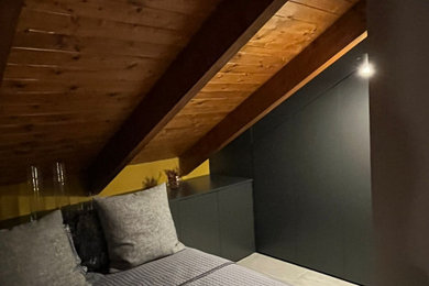 Immagine di un'In mansarda camera degli ospiti minimalista di medie dimensioni con pareti gialle, pavimento in gres porcellanato, pavimento grigio e travi a vista