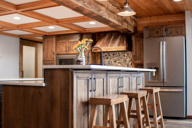 Inspiration for a rustic kitchen remodel in Minneapolis with a farmhouse sink, dark wood cabinets, multicolored backsplash, stainless steel appliances, two islands and beige countertops