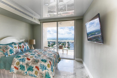 Large transitional guest porcelain tile and gray floor bedroom photo in Miami with gray walls and no fireplace