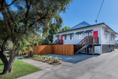 Inspiration for a large two-storey exterior in Brisbane with a butterfly roof, a metal roof and a blue roof.