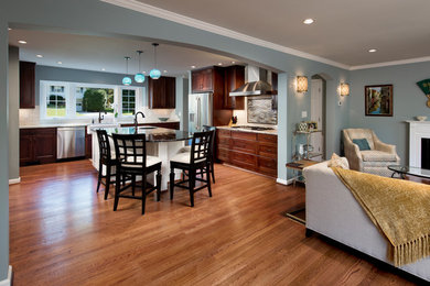 Example of a large transitional eat-in kitchen design in DC Metro with a farmhouse sink, shaker cabinets, medium tone wood cabinets, granite countertops, white backsplash, subway tile backsplash, stainless steel appliances and an island
