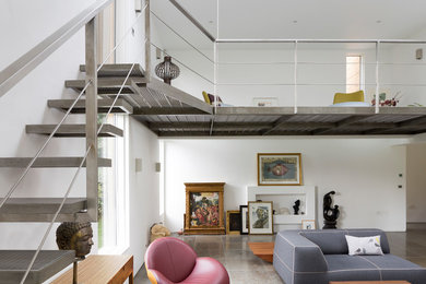 Large contemporary mezzanine living room in Cambridgeshire with white walls, porcelain flooring, brown floors and no tv.