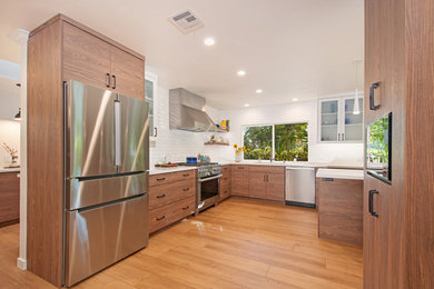 Inspiration for a large transitional l-shaped vinyl floor and beige floor eat-in kitchen remodel in San Diego with an undermount sink, flat-panel cabinets, brown cabinets, quartz countertops, white backsplash, subway tile backsplash, stainless steel appliances, an island and white countertops