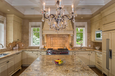 Large elegant u-shaped medium tone wood floor eat-in kitchen photo in Vancouver with a double-bowl sink, raised-panel cabinets, yellow cabinets, granite countertops, brown backsplash, stone tile backsplash, paneled appliances and an island