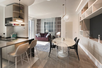 Inspiration for a large modern kitchen/dining combo in Milan with white walls, light hardwood floors and recessed.