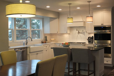 Eat-in kitchen - mid-sized transitional u-shaped dark wood floor eat-in kitchen idea in Columbus with an island, flat-panel cabinets, white cabinets, quartz countertops, white backsplash, ceramic backsplash, stainless steel appliances and a farmhouse sink