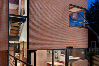 Example of an urban red brick flat roof design in Seattle