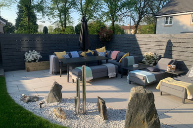 Design ideas for a large contemporary back patio in Glasgow with a water feature.