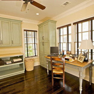 Ejemplo de lavadero multiusos y en L, clásico, grande, con suelo de madera oscura, fregadero de un seno, armarios con paneles empotrados, puertas de armario con efecto envejecido, lavadora y secadora apiladas, suelo marrón, encimeras beige y paredes beige