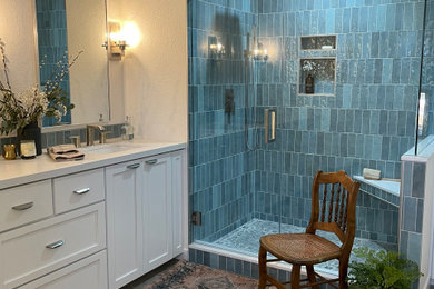 Inspiration for a large transitional master blue tile and porcelain tile porcelain tile, gray floor, double-sink and brick wall bathroom remodel in Los Angeles with shaker cabinets, white cabinets, white walls, an undermount sink, quartz countertops, a hinged shower door, white countertops and a built-in vanity