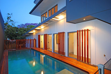 This is an example of a mid-sized contemporary courtyard rectangular pool in Brisbane with decking.