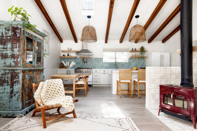 Imagen de salón tipo loft costero pequeño con suelo de baldosas de cerámica, estufa de leña y marco de chimenea de baldosas y/o azulejos
