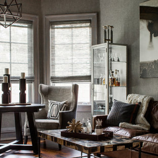 Bild på ett mellanstort rustikt hemmabibliotek, med grå väggar, mellanmörkt trägolv och ett inbyggt skrivbord