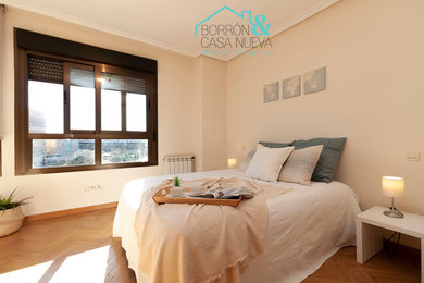 Ejemplo de dormitorio contemporáneo de tamaño medio con paredes beige y suelo de madera en tonos medios