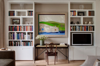 This is an example of a transitional home office in London with grey walls, light hardwood floors, a freestanding desk and a library.