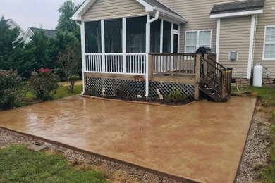 Photo of a mid-sized traditional backyard patio in Raleigh with stamped concrete and no cover.