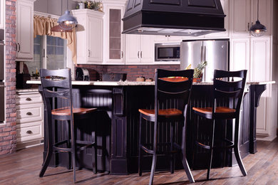 Example of a large classic l-shaped eat-in kitchen design in Cleveland with raised-panel cabinets and an island