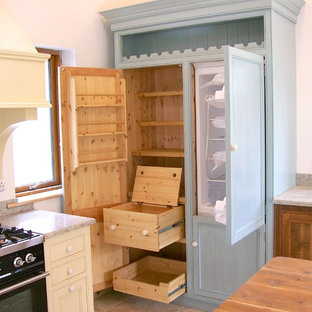 Cette image montre une arrière-cuisine traditionnelle avec des portes de placard bleues et un sol en bois brun.