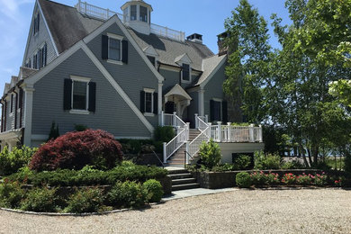 Example of a large classic gray two-story wood exterior home design in New York with a shingle roof