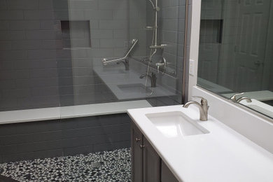 This is an example of a mid-sized modern master bathroom in Portland with shaker cabinets, grey cabinets, an open shower, gray tile, ceramic tile, white walls, porcelain floors, an undermount sink, engineered quartz benchtops, grey floor, an open shower, white benchtops, a shower seat, a double vanity and a built-in vanity.