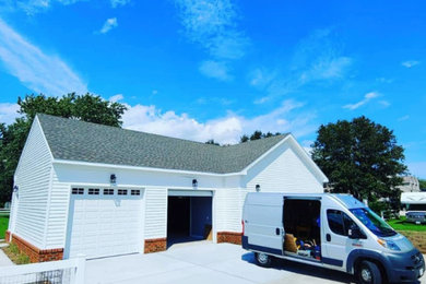 Example of a large beach style detached two-car carport design in Other