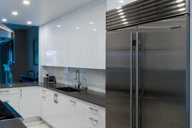 Inspiration for a large contemporary separate kitchen in Toronto with an undermount sink, flat-panel cabinets, white cabinets, quartz benchtops, white splashback, stainless steel appliances, porcelain floors, a peninsula, white floor and grey benchtop.
