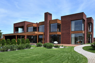 Foto della villa grande marrone contemporanea a due piani con rivestimento in mattoni e tetto piano