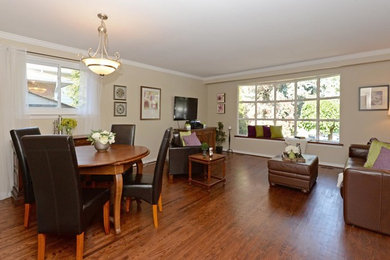 Inspiration for a mid-sized timeless open concept medium tone wood floor and brown floor living room remodel in Toronto with beige walls, no fireplace and a wall-mounted tv
