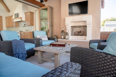 Large transitional backyard patio photo in Los Angeles with a fireplace and a roof extension