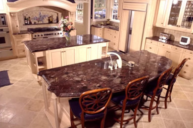 Open concept kitchen - large l-shaped limestone floor open concept kitchen idea in Milwaukee with a double-bowl sink, light wood cabinets, granite countertops, beige backsplash, ceramic backsplash and stainless steel appliances