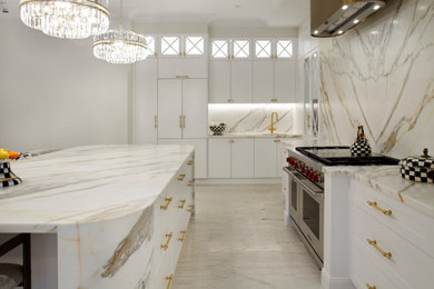 Photo of a large l-shaped open plan kitchen in Sydney with an undermount sink, shaker cabinets, white cabinets, marble benchtops, marble splashback, stainless steel appliances, porcelain floors and with island.
