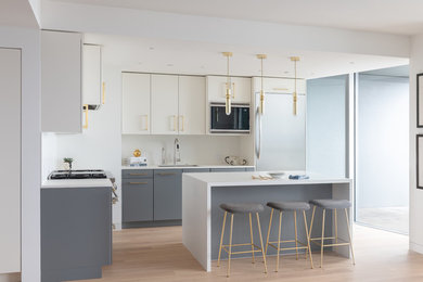 Inspiration for a contemporary eat-in kitchen in San Francisco with an undermount sink, grey cabinets, white splashback, stainless steel appliances, with island, beige floor and white benchtop.