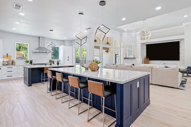 This is an example of a modern eat-in kitchen in Atlanta with shaker cabinets, white cabinets and multiple islands.