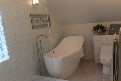 Photo of a mid-sized transitional master bathroom in Orange County with flat-panel cabinets, white cabinets, a freestanding tub, an open shower, a one-piece toilet, gray tile, white tile, matchstick tile, white walls, ceramic floors, a vessel sink, solid surface benchtops, beige floor and a hinged shower door.