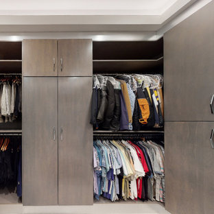 Modern inredning av ett stort walk-in-closet för män, med släta luckor, grå skåp, klinkergolv i porslin och beiget golv