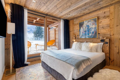 Cette photo montre une chambre parentale montagne en bois de taille moyenne avec un mur beige, parquet clair, un sol beige, poutres apparentes et dressing.