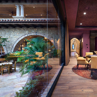 Abgetrennter Mediterraner Hobbyraum mit lila Wandfarbe und Wand-TV in Houston