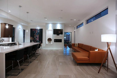 Large trendy open concept porcelain tile living room photo in Houston with white walls, a standard fireplace, a tile fireplace and a wall-mounted tv