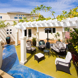 Photo of a large beach style front yard patio in San Diego with stamped concrete and a pergola.