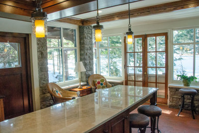 Photo of a mid-sized traditional galley open plan kitchen in Minneapolis with a single-bowl sink, flat-panel cabinets, brown cabinets, granite benchtops, stainless steel appliances, with island, brown floor and white benchtop.