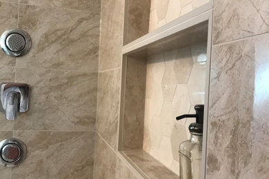Example of a mid-sized transitional master beige tile and porcelain tile porcelain tile, beige floor and double-sink bathroom design with shaker cabinets, dark wood cabinets, beige walls, an undermount sink, granite countertops, a hinged shower door, beige countertops, a niche and a built-in vanity