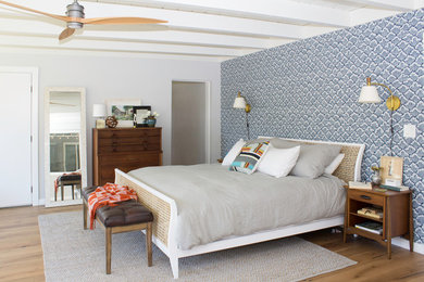 Large mid-century modern master medium tone wood floor bedroom photo in San Diego with blue walls and no fireplace