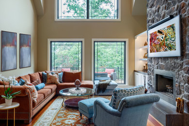 シャーロットにある高級な小さなトランジショナルスタイルのおしゃれな独立型リビング (黄色い壁、無垢フローリング、標準型暖炉、石材の暖炉まわり、壁掛け型テレビ、赤い床、三角天井) の写真