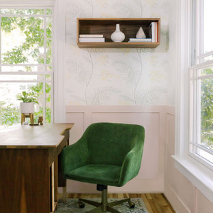 Klassisches Arbeitszimmer mit rosa Wandfarbe, hellem Holzboden, braunem Boden und vertäfelten Wänden in Austin